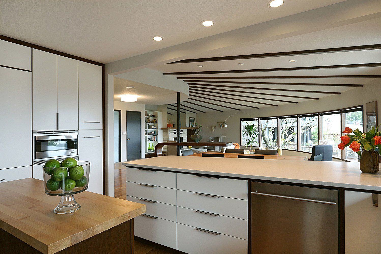 Custom walnut cabinets with white drawer & door faces pay tribute to the  ceiling ribs