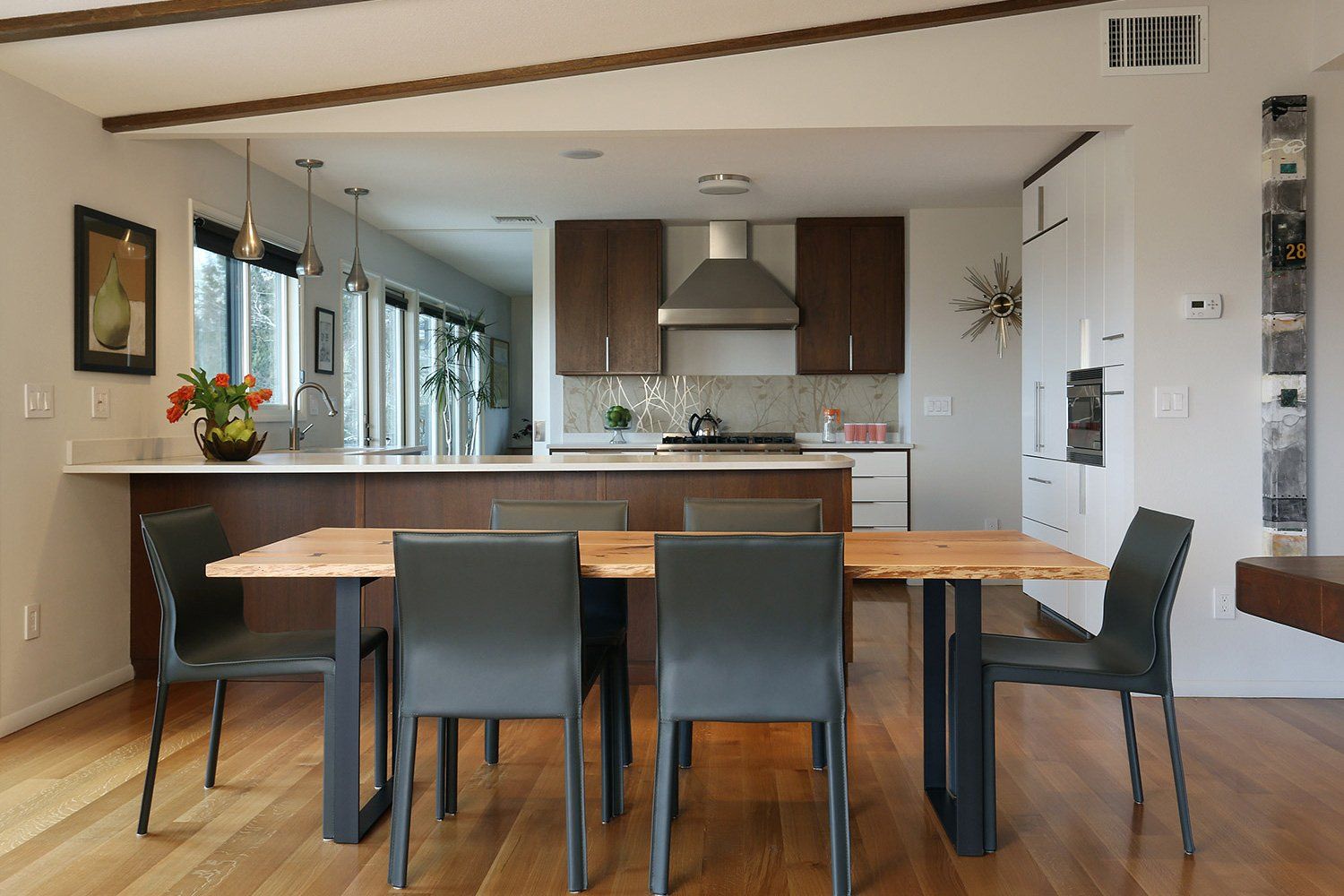 The dining table is near the kitchen & living spaces