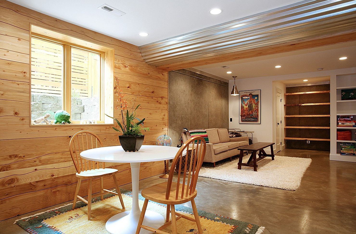 In the daylight basement, salvaged paneling set horizontally creates a cozy feeling in the family room