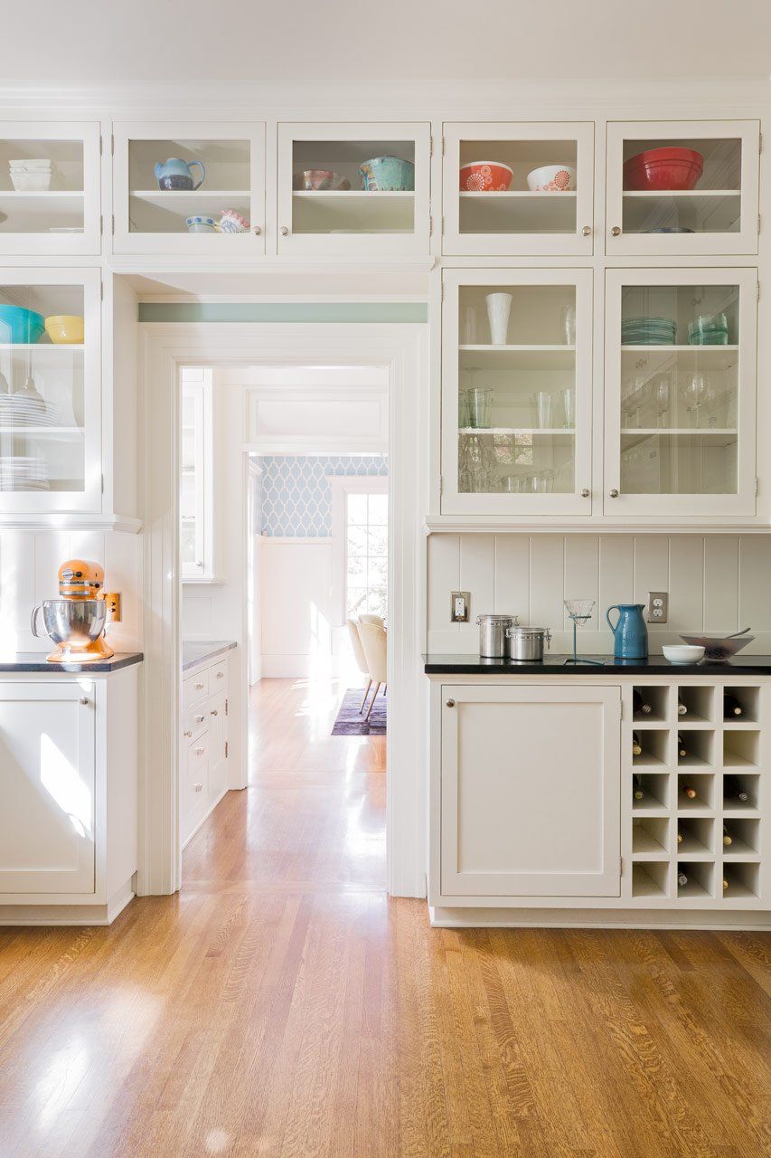 Looking through the kitchen's cased opening at the pass-through butler’s pantry with the dining room in the distance.
