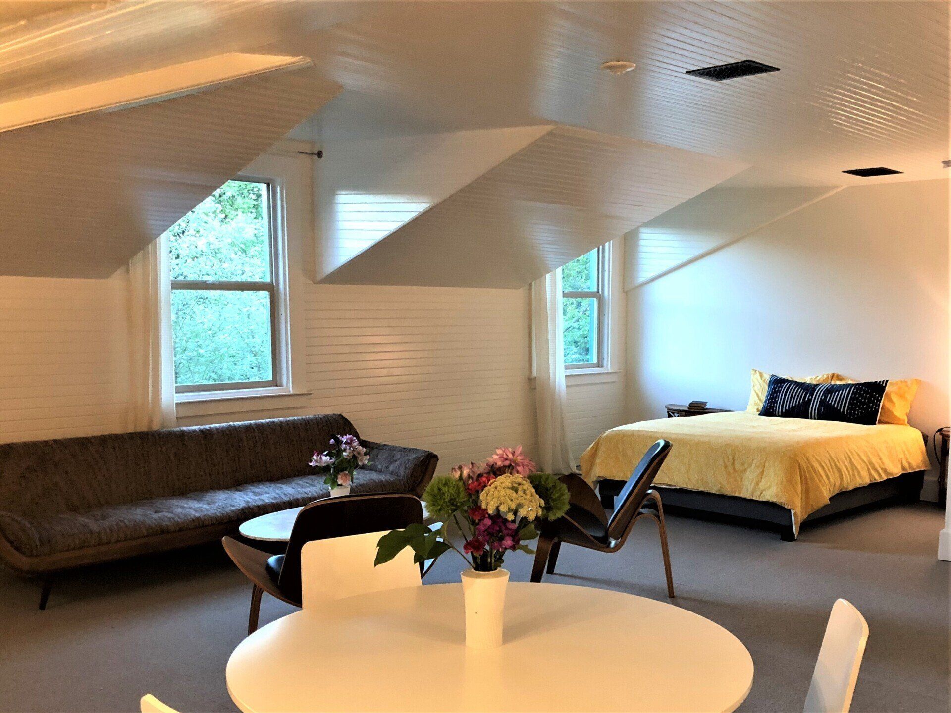 A living room with a couch , table , chairs and a bed