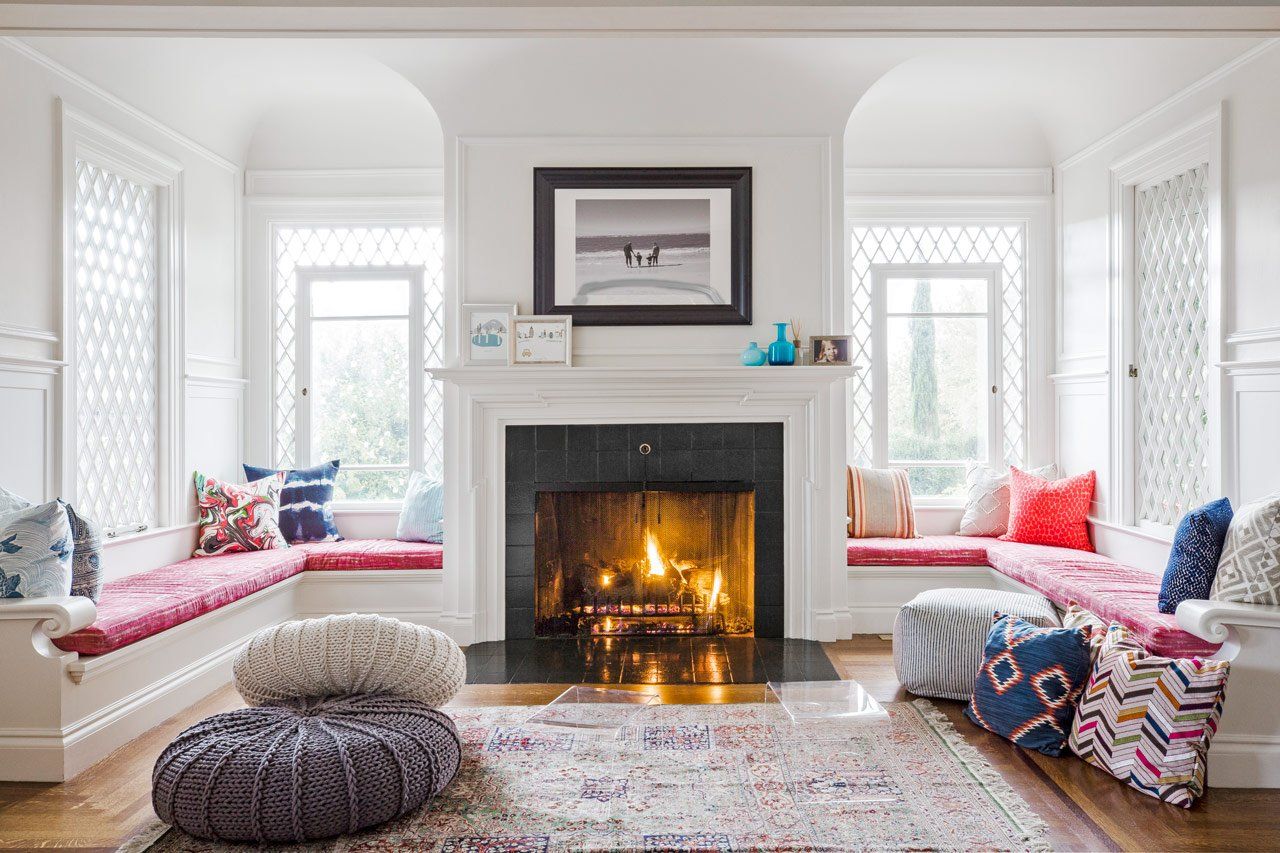 Wide view of the symmetrical living room, built in benches flanking the original fireplace.