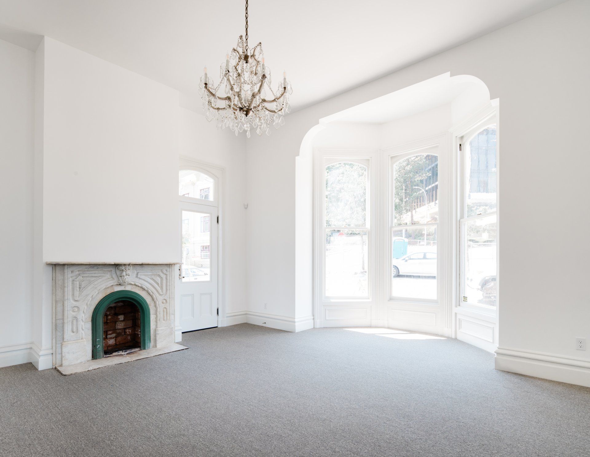 The parlour boasts a bay window with a segmental arch and a restored marble fireplace surround.