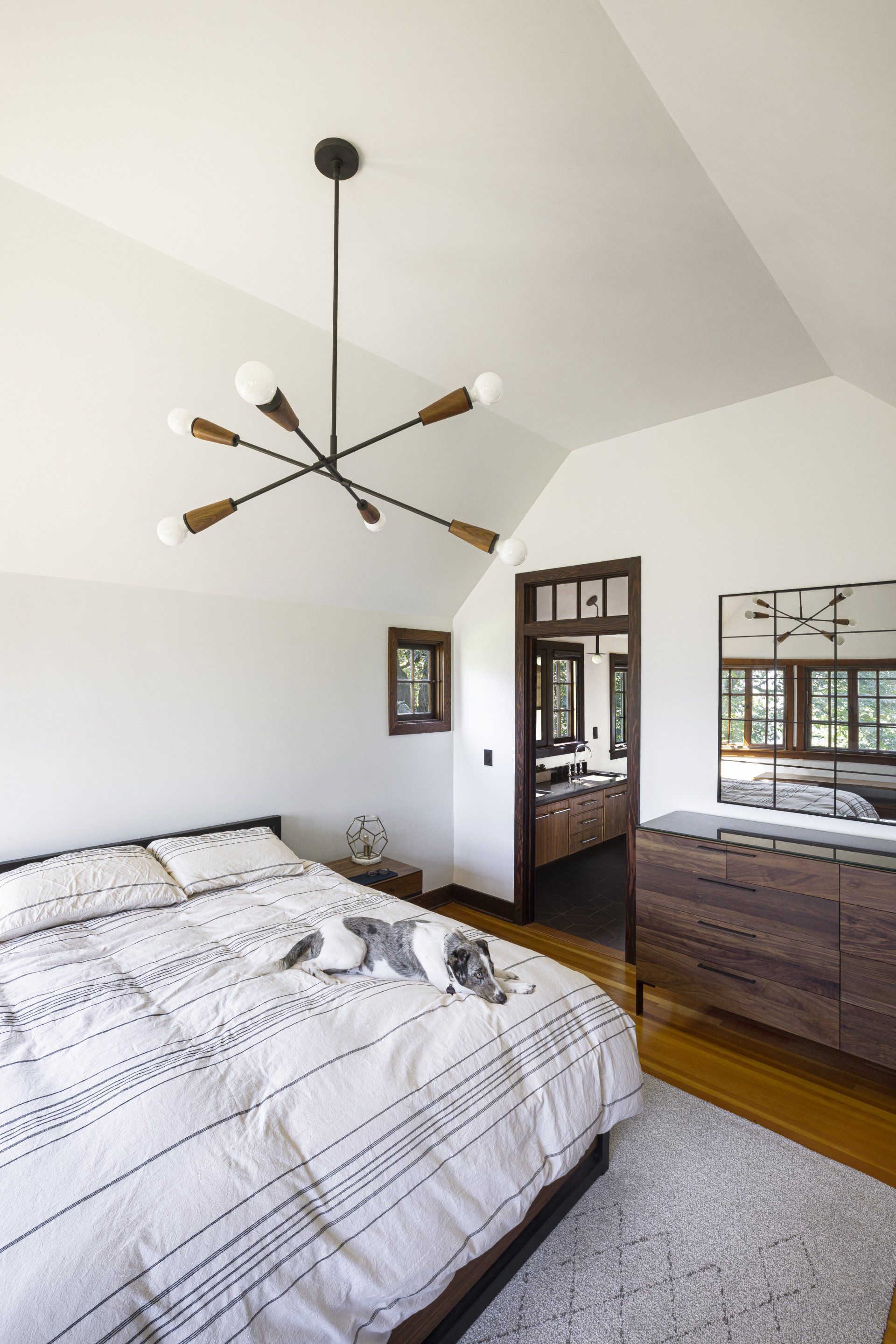 The main bedroom upstairs has a simple palette of white and wood tones
