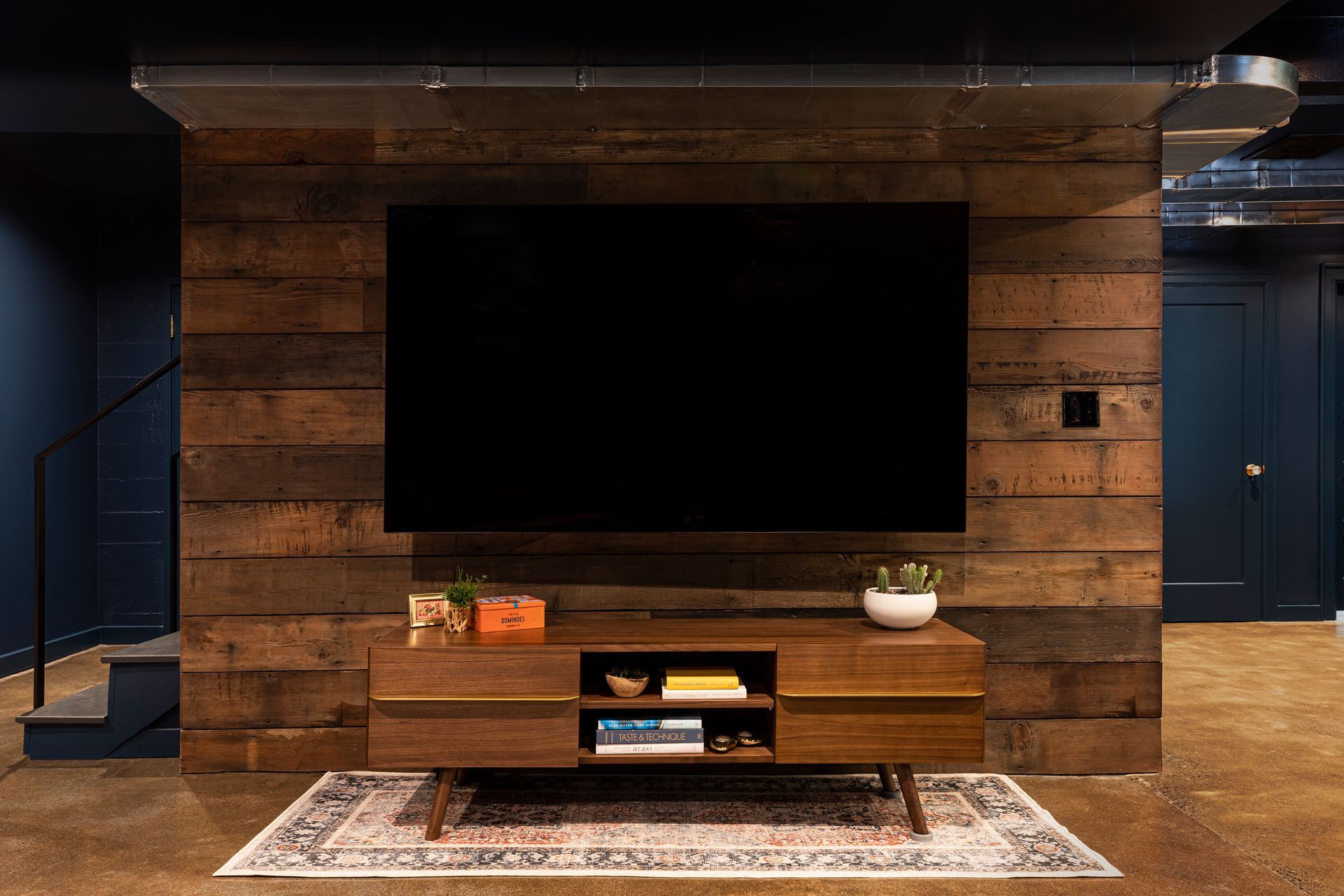 Wood paneled wall in remodeled basement and entertainment center.