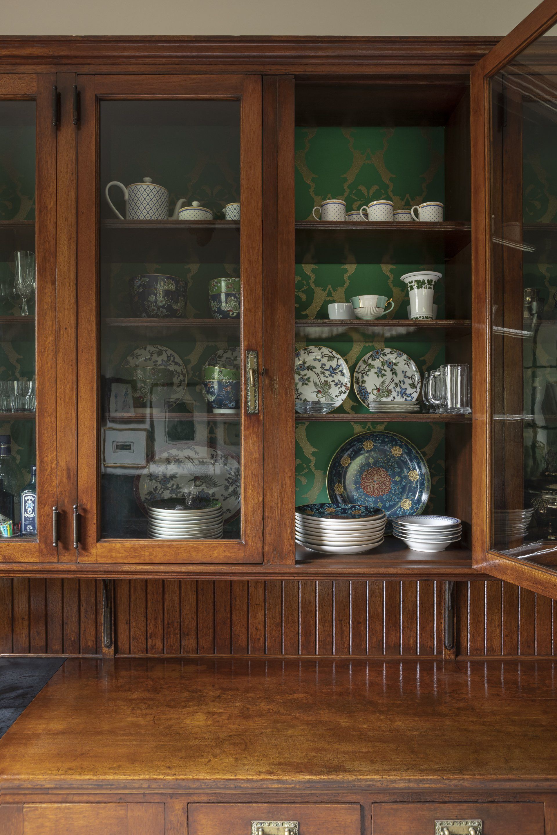 Original China Room oak built-ins with ornate hardware and eclectic China collection visible in upper cabinets.