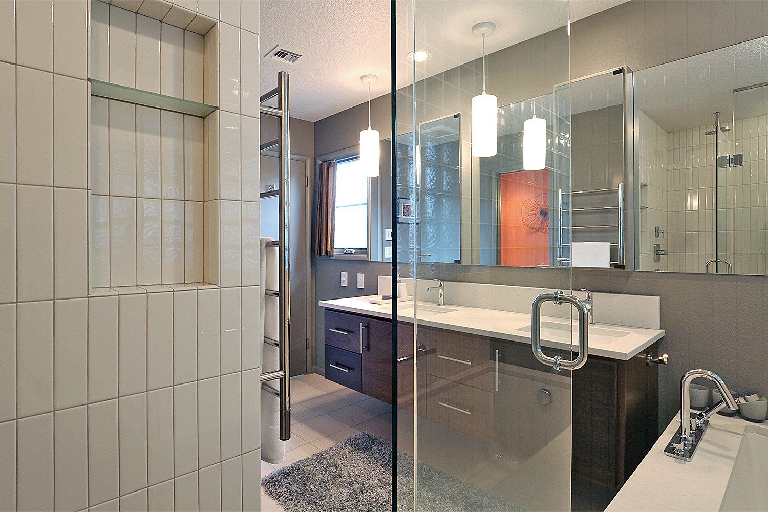 Reflective surfaces & a custom floating vanity cabinet create a luxurious space in the main bath