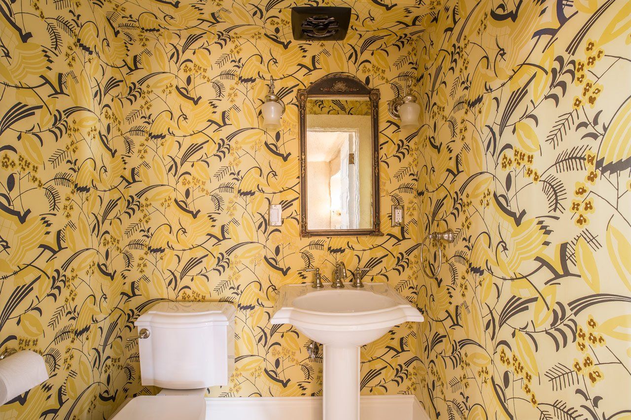 At the main stairs, the WC has yellow art deco wallpaper with stylized birds.