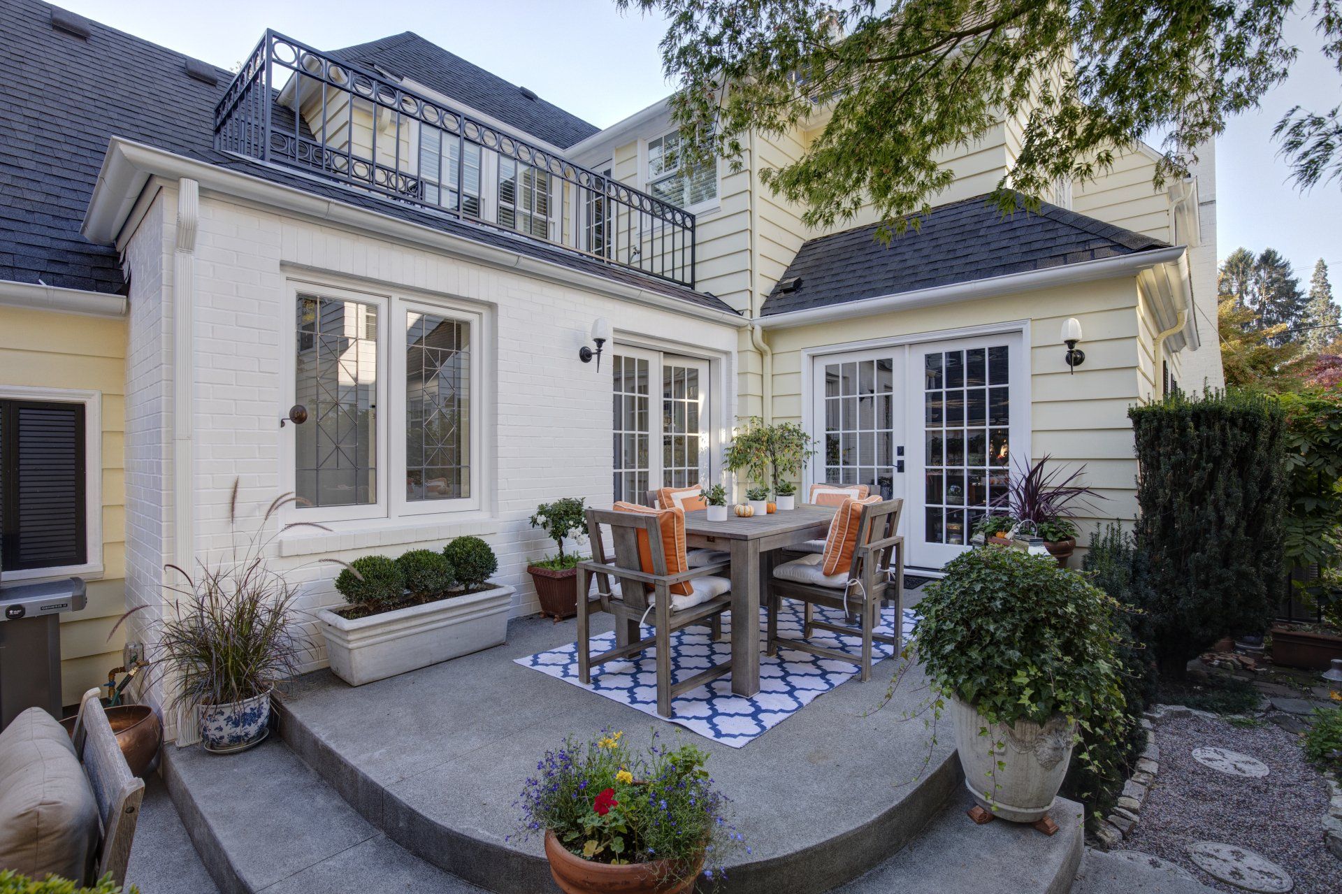 Looking  at the back patio with a bedroom balcony in the rear.