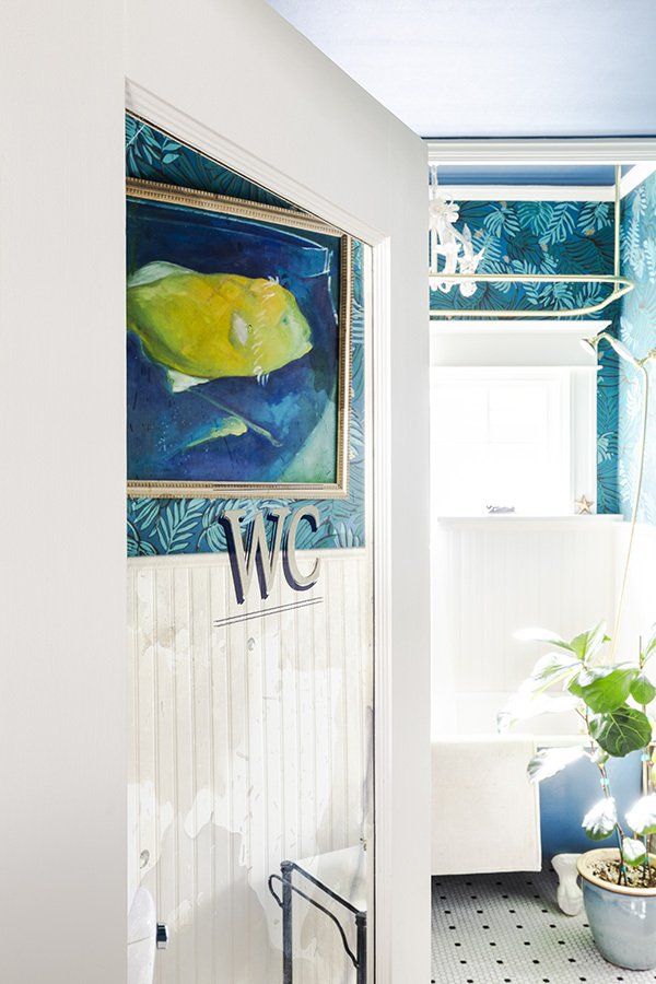 The WCs door has an antiqued mirror panel which leads you to the original bath, decked out in colors of the sea with crisp white trim.