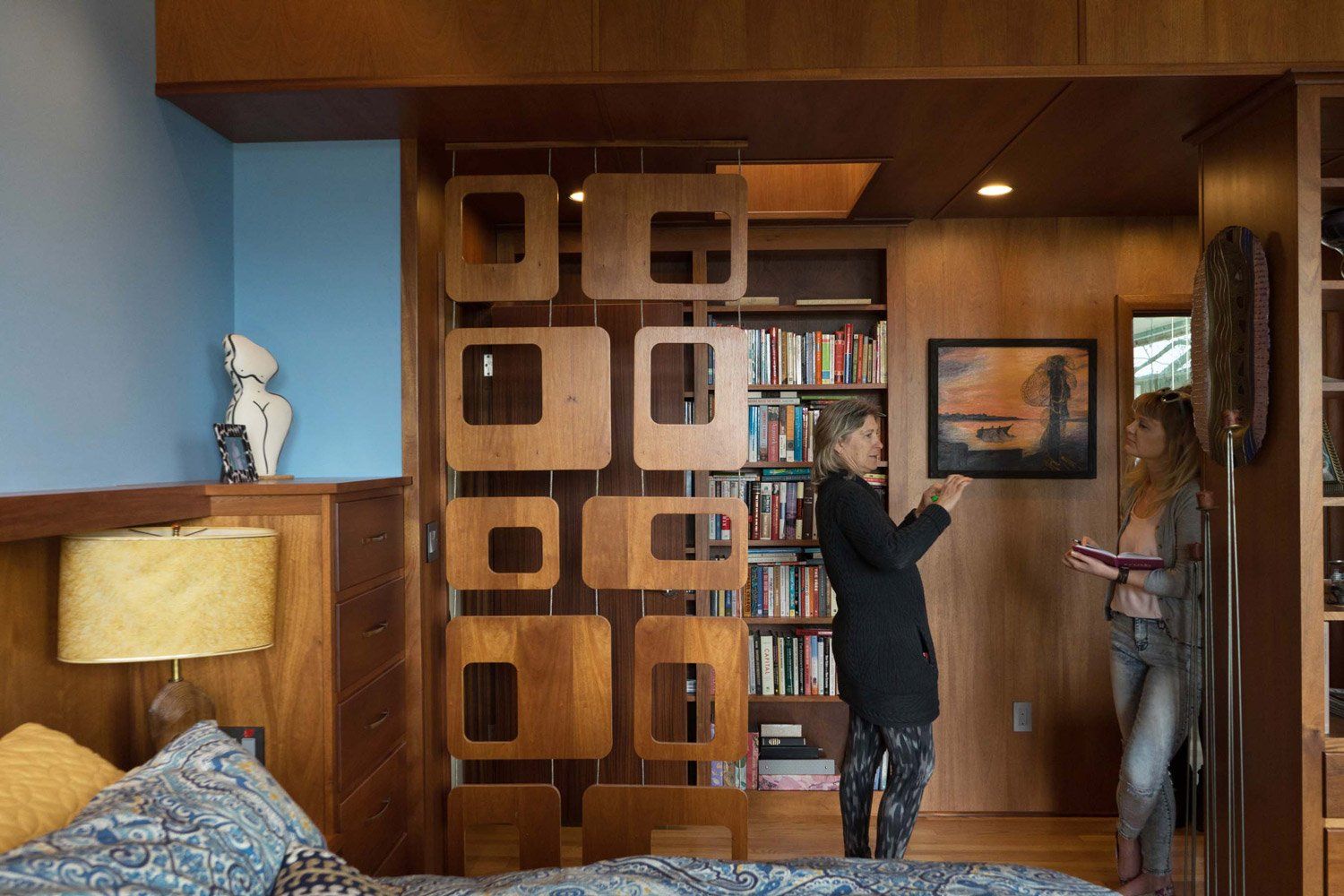 The paneled ante room is separated from the master bedroom by a custom geometric screen.