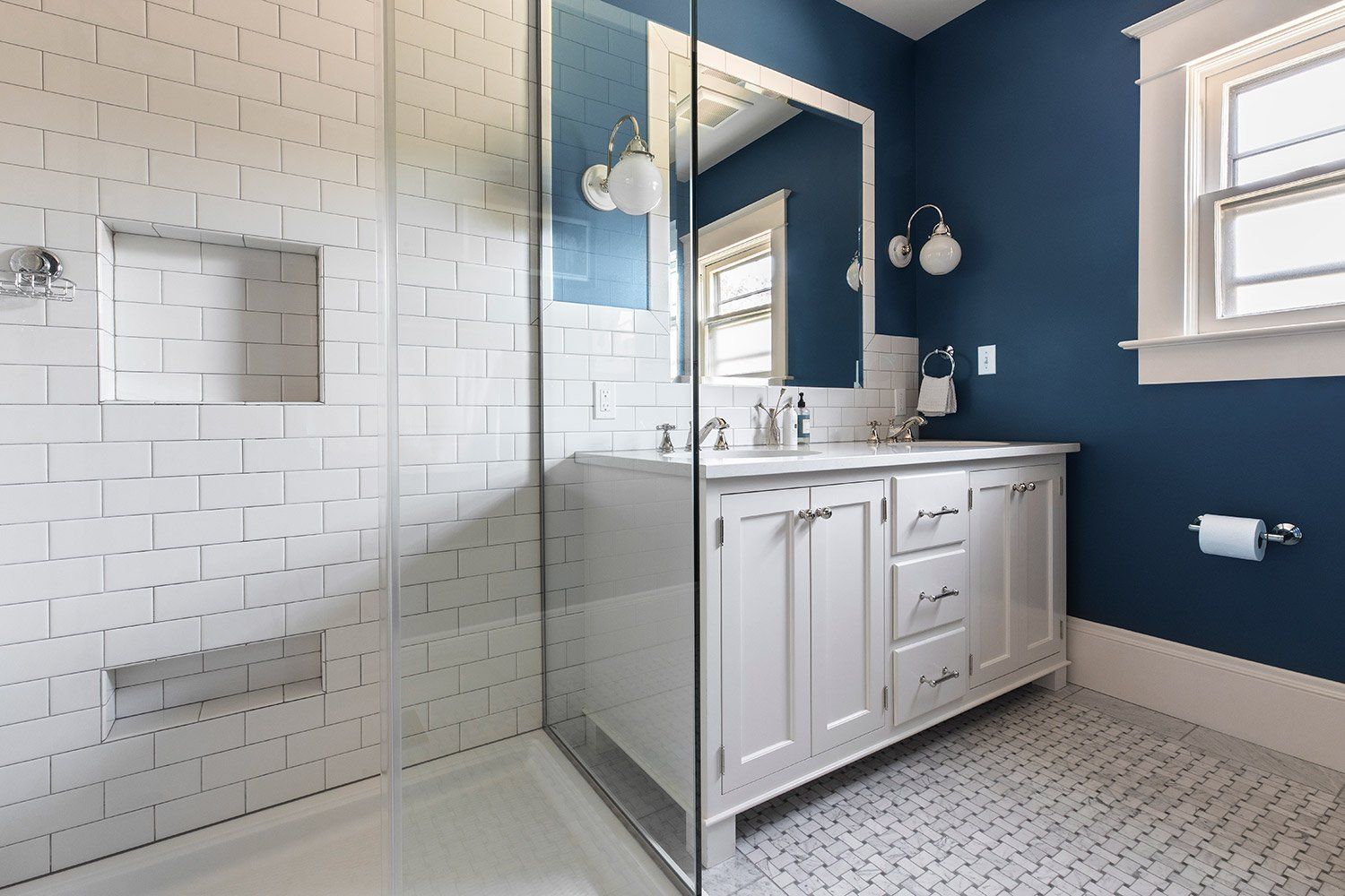 The main bath feels luxe with radiant-heated marble floors, a roomy shower and double vanity with deep blue walls.