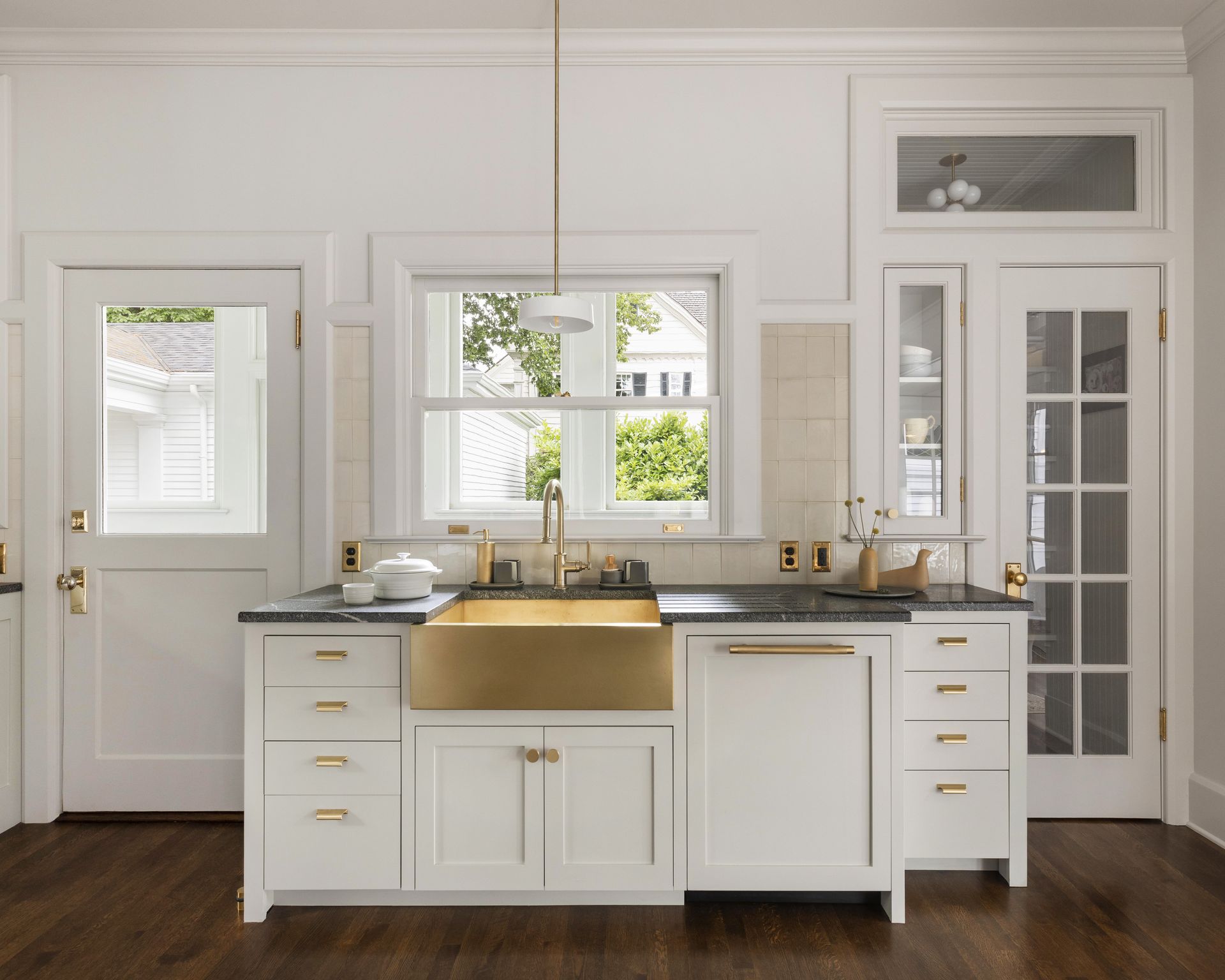 A dishwashing station with soapstone counters, brass apron sink and walk-in pantry.