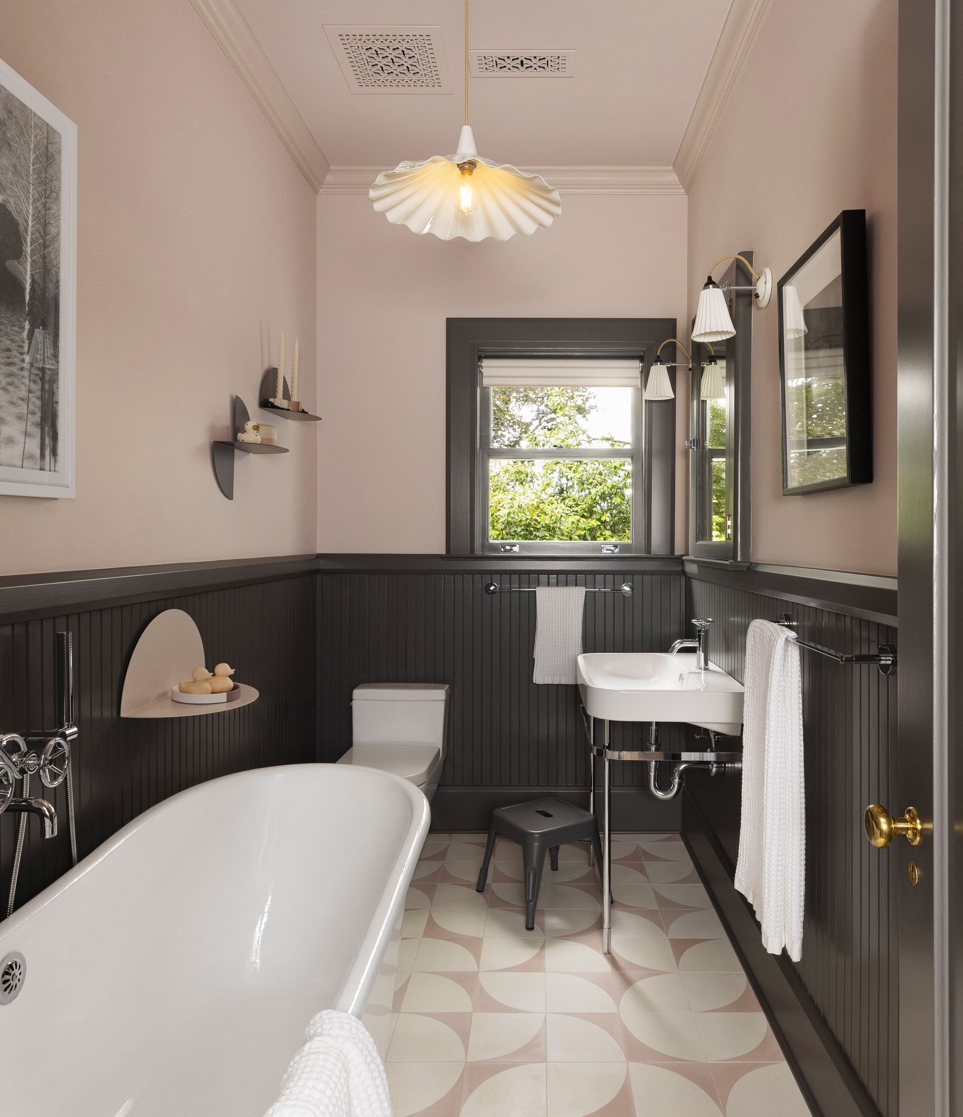 Remodeled 1920’s bathroom with contemporary sink, painted wainscoting and pink and white concrete tile floor.