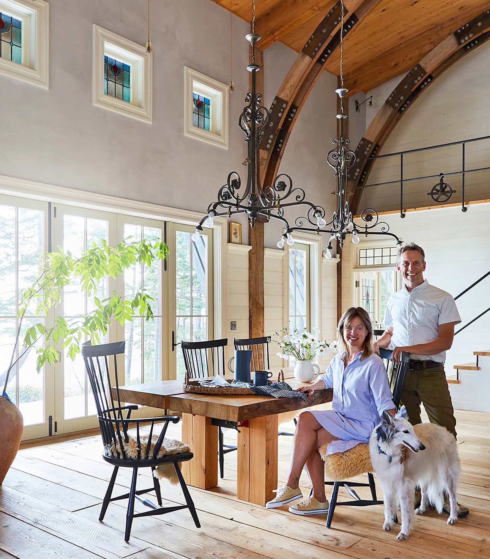 A man and a woman are sitting at a table with a dog.