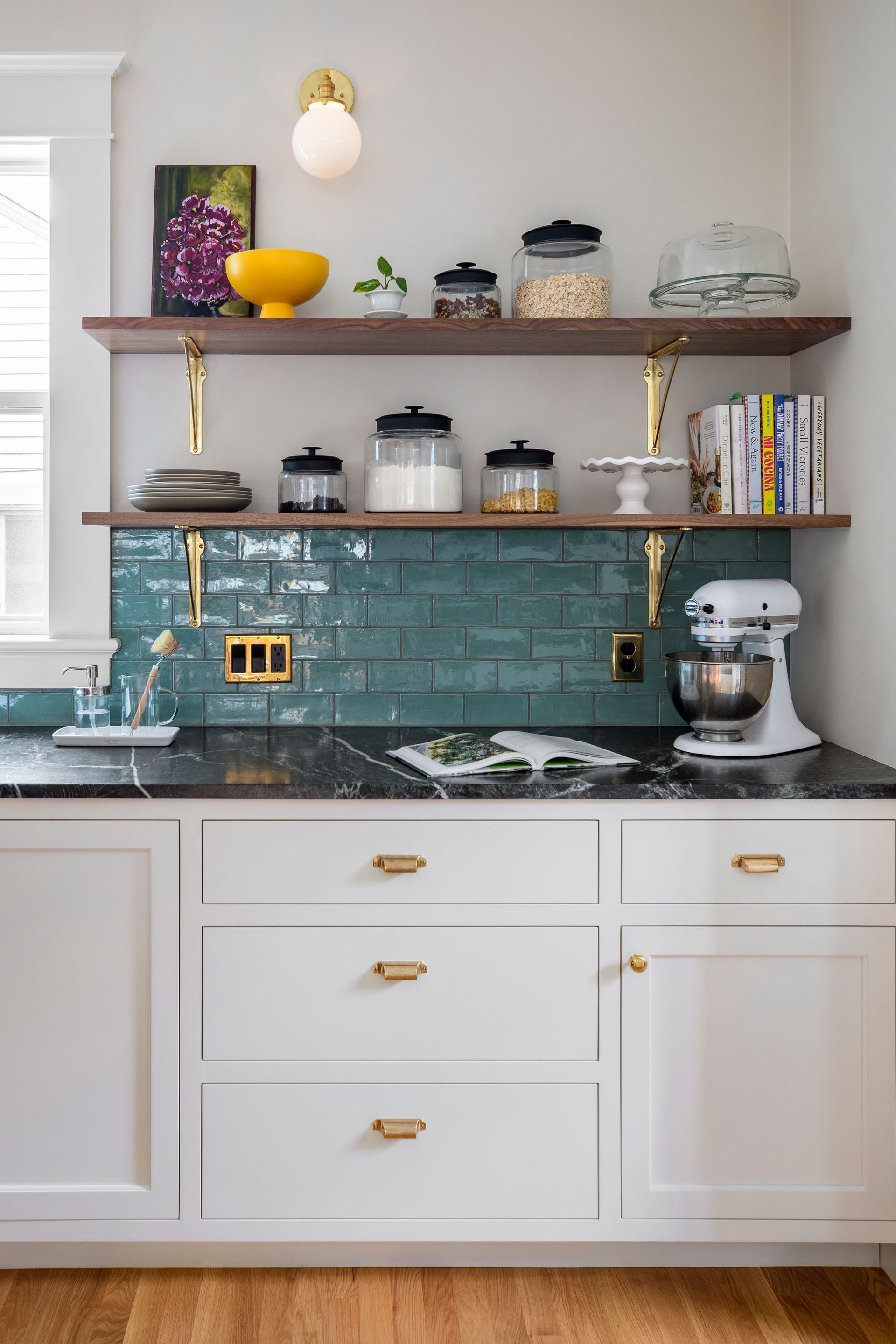 A built-in storage pantry allows for the space on either side of the sink to be fitted with open shelving rather than cabinets. 