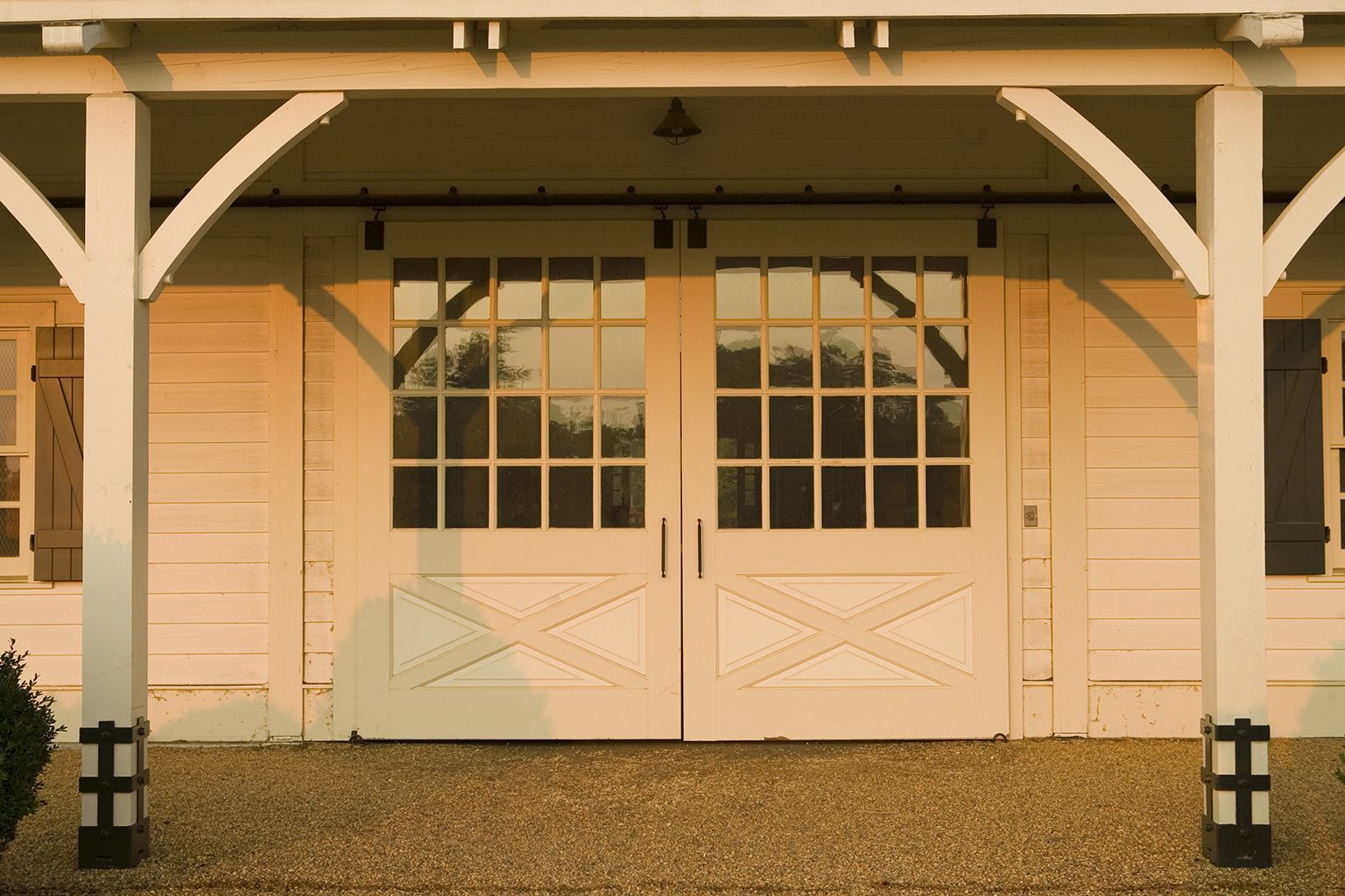 A white house with a covered porch and a sliding barn door