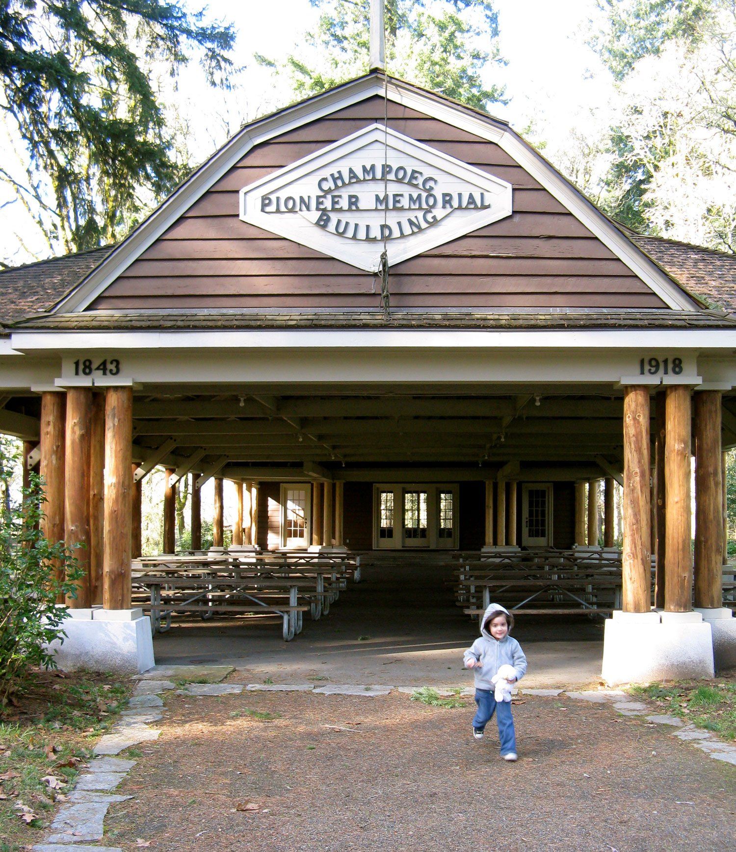 A child stands in front of a building that says pioneer memorial building