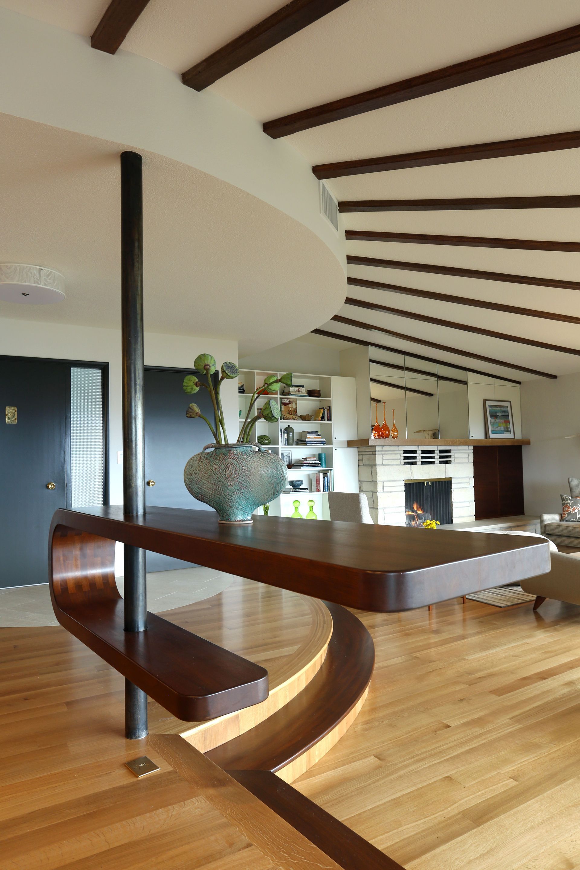 Close up of the custom, curved wooden shelf which sits at the edge of the living room