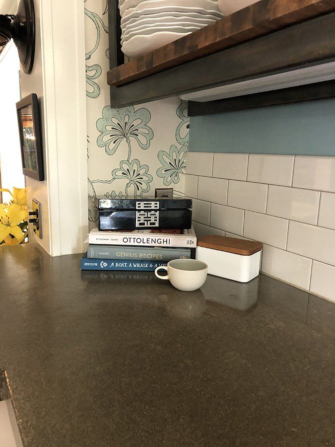 Cookbooks; a box from Shanghai; mug by Heath Ceramics; wallpaper by Florence Broahdhurst; hand-poured concrete countertop by ARCIFORM