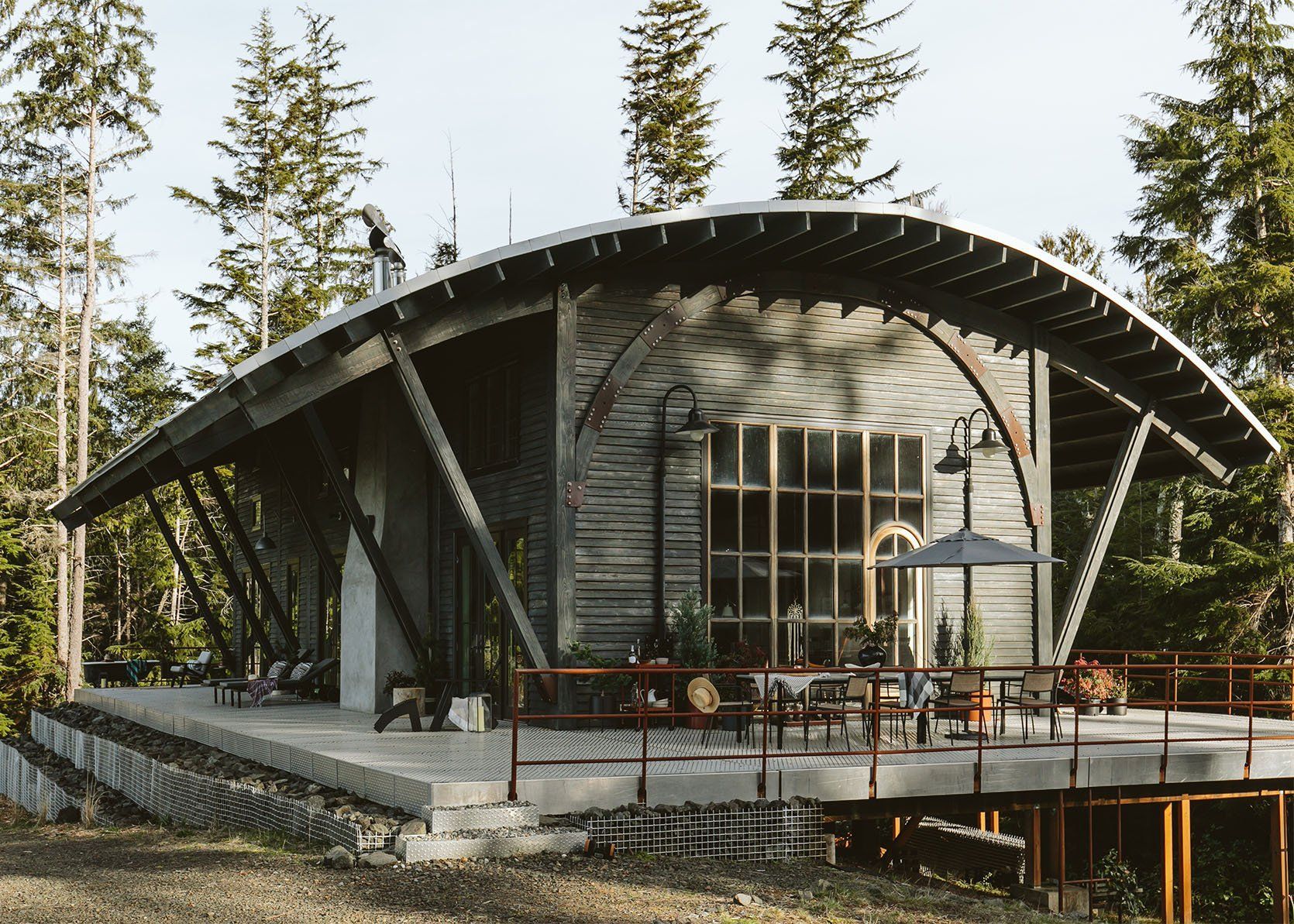 A large house with a curved roof is surrounded by trees.