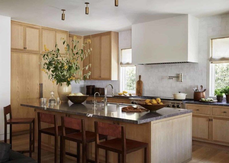A kitchen with wooden cabinets , stainless steel counter tops , and a large island.
