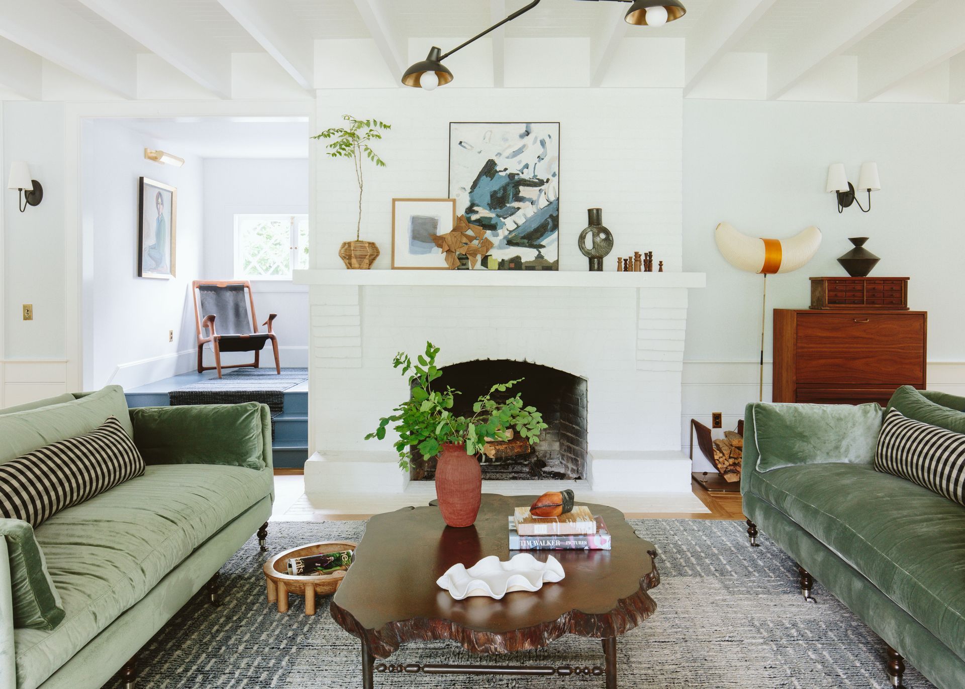 A living room with two green couches and a fireplace.