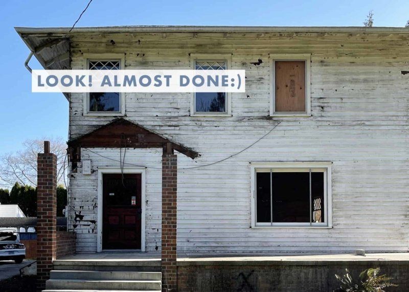 A white house with a sign that says look ! almost done