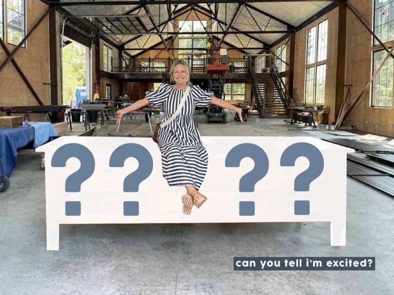 A woman in a striped dress is sitting on a bed with question marks on it.