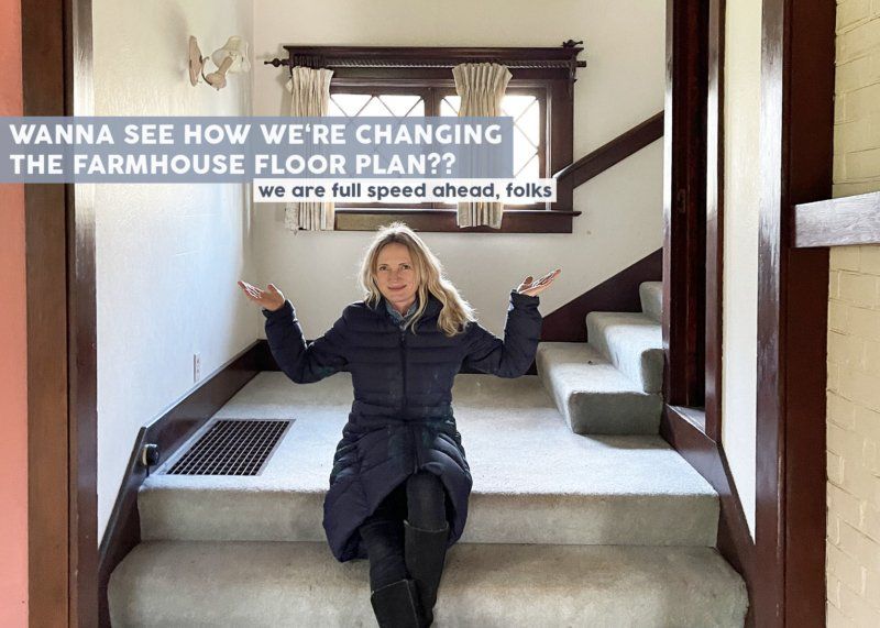 A woman is sitting on a set of stairs in a house.