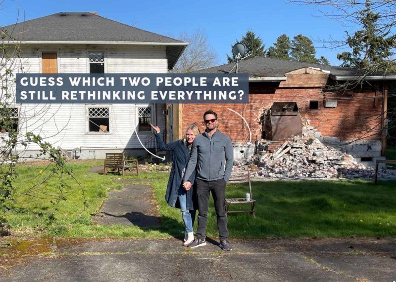 A man and a woman are standing in front of a house that is being demolished.