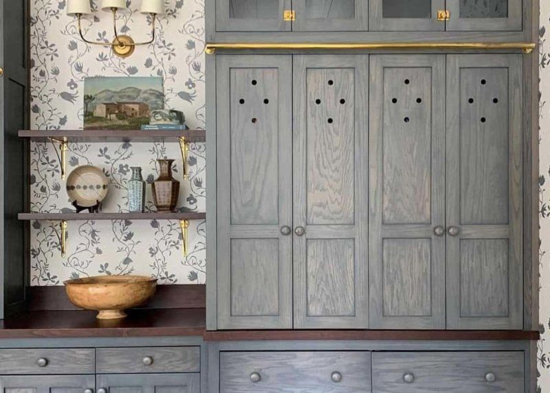 A room with a lot of cabinets and shelves and a bowl on the counter.