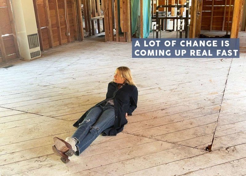 A woman is laying on the floor of a building under construction.