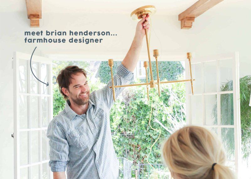 A man is fixing a chandelier in a room while a woman looks on ..