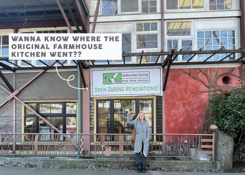 A woman is standing in front of a building with a sign that says wanna know where the original farmhouse kitchen went ?