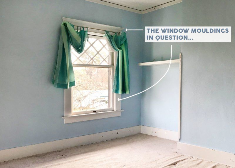 A room with blue walls and a window with green curtains.