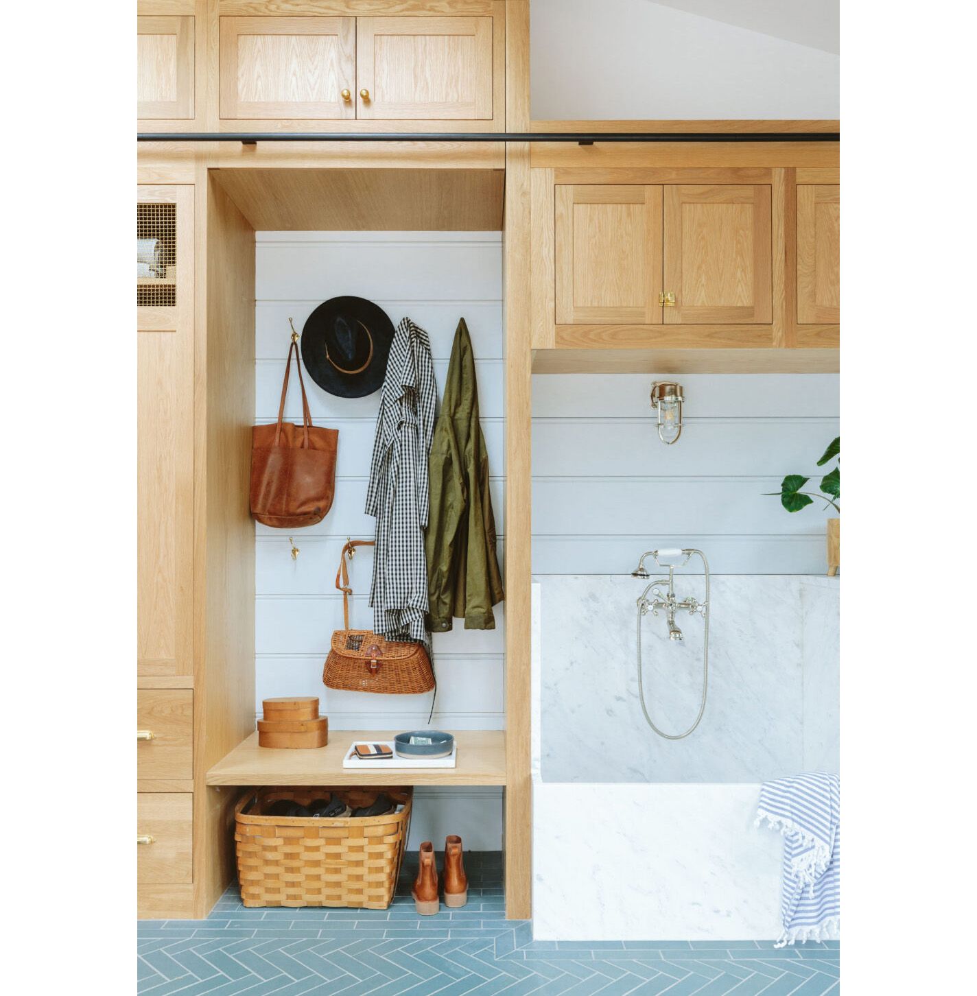 In Emily Henderson's well-equipped mudroom a mix of open cubbies (lined with hooks)  and concealed cupboards provide a wealth of storage options. 