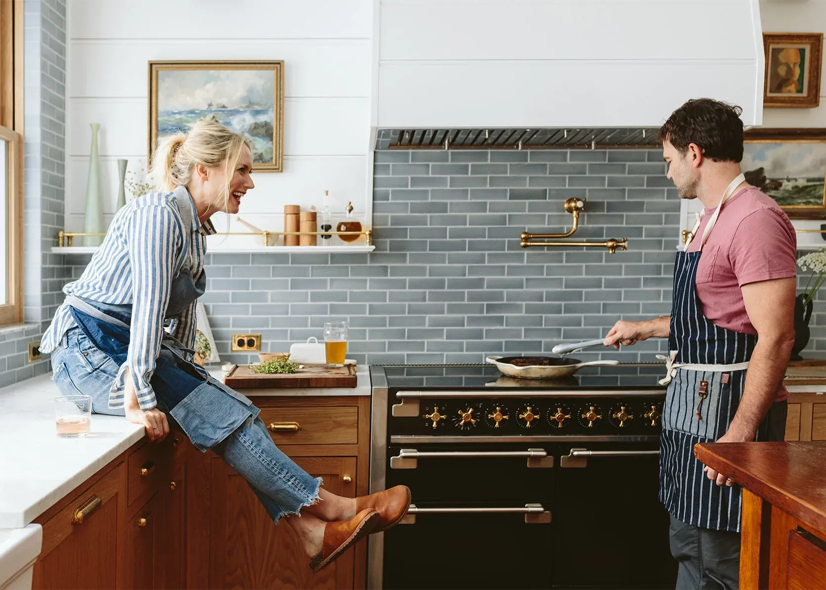 A man and a woman are cooking together in a kitchen.