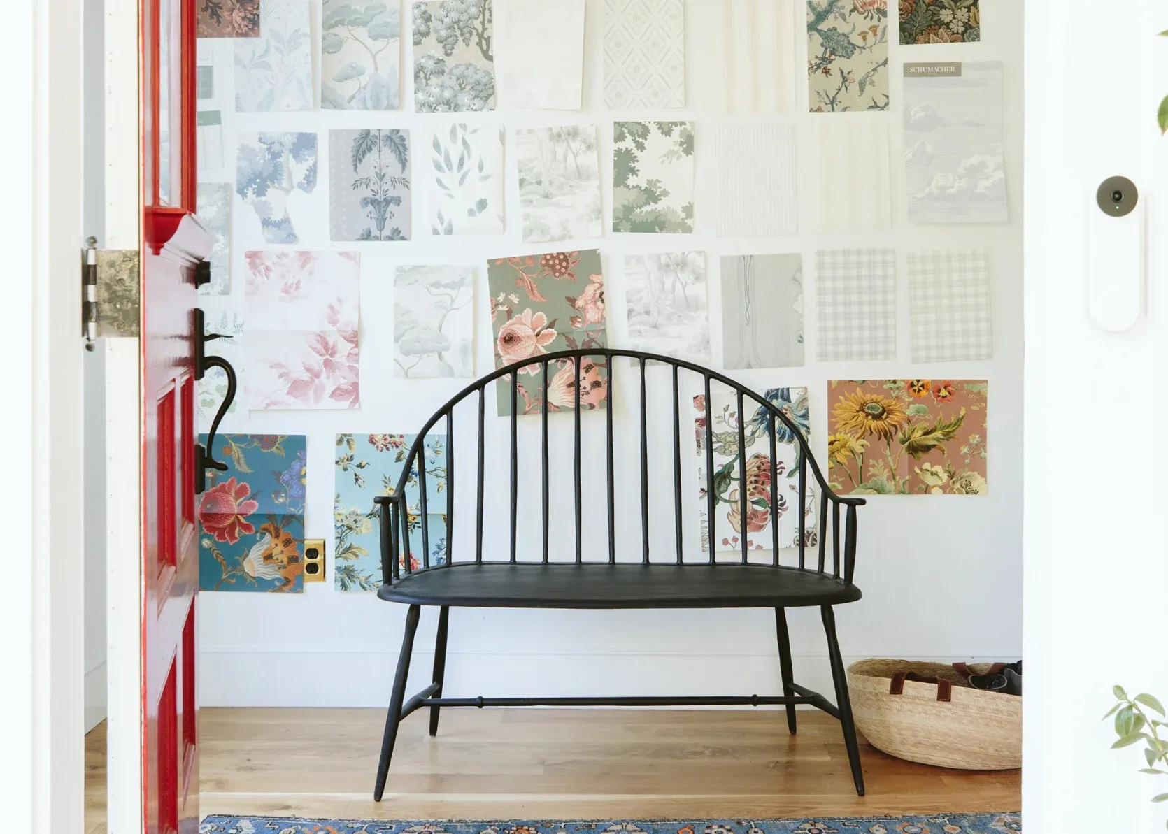 A black bench is sitting in front of a wall with pictures on it.