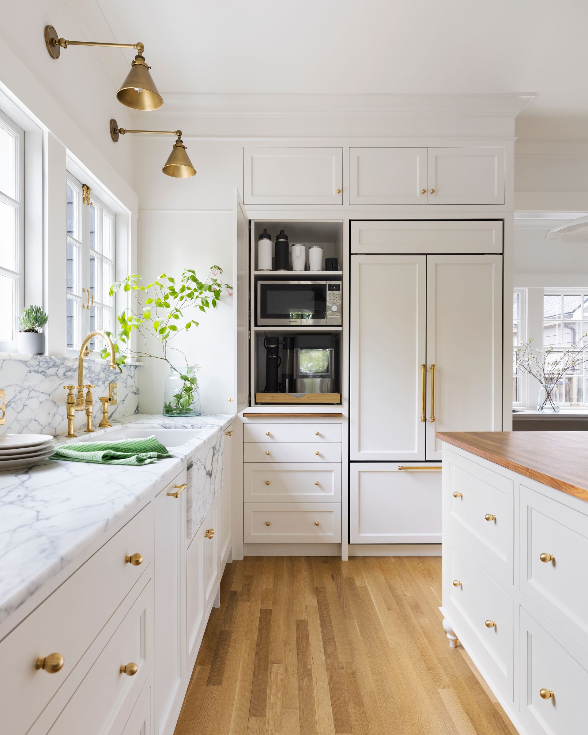 The full height cabinets, door open, to show the microwave and coffee station nestled next to the integrated fridge.