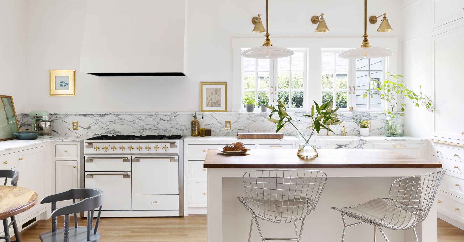 A kitchen with white cabinets , stainless steel appliances , and a large island.