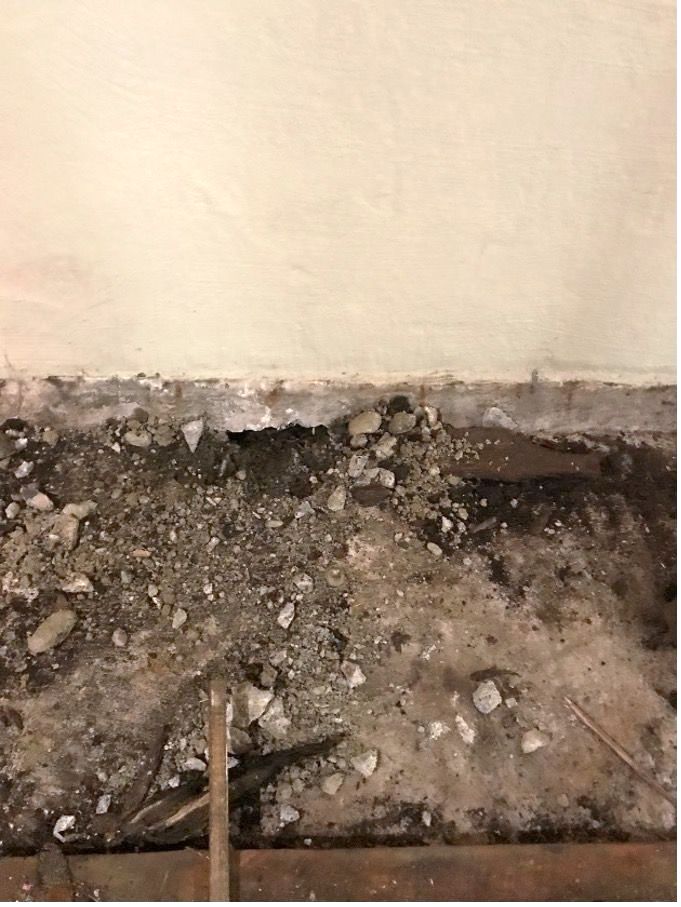 A close up of a concrete floor next to a wall.