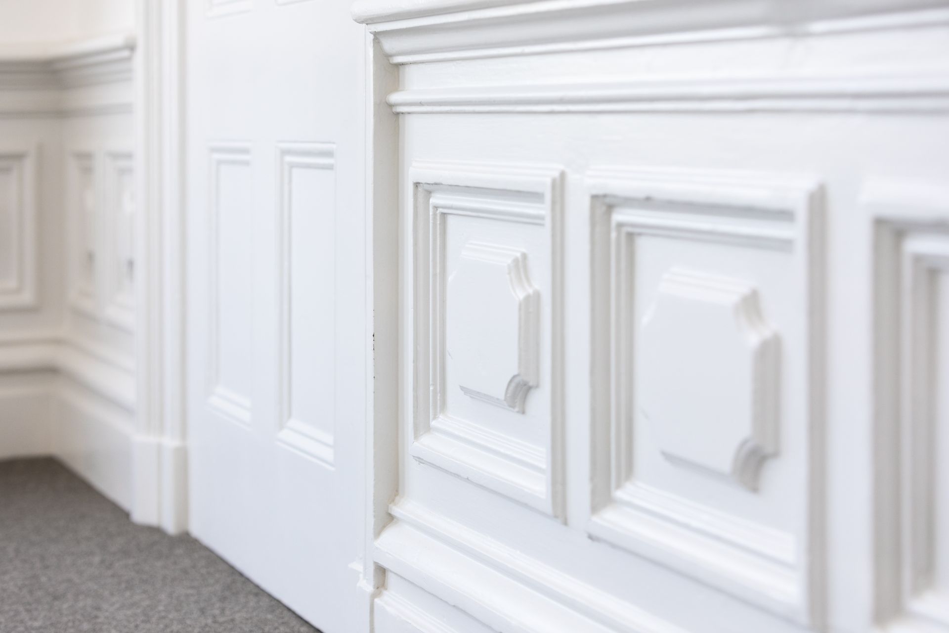 A close up of a white wall with molding in a room.
