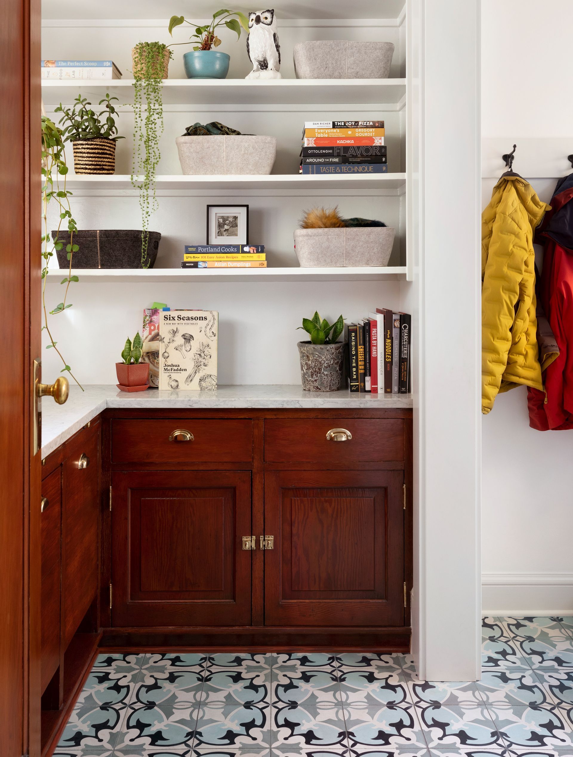 For this small mudroom entryway, we opened up the wall between a cramped side entry and an original butler’s pantry, making the sweet existing space more of a feature.  The simple mudroom layout allows for hooks and a bench in the entry as it is tucked away around the corner.   