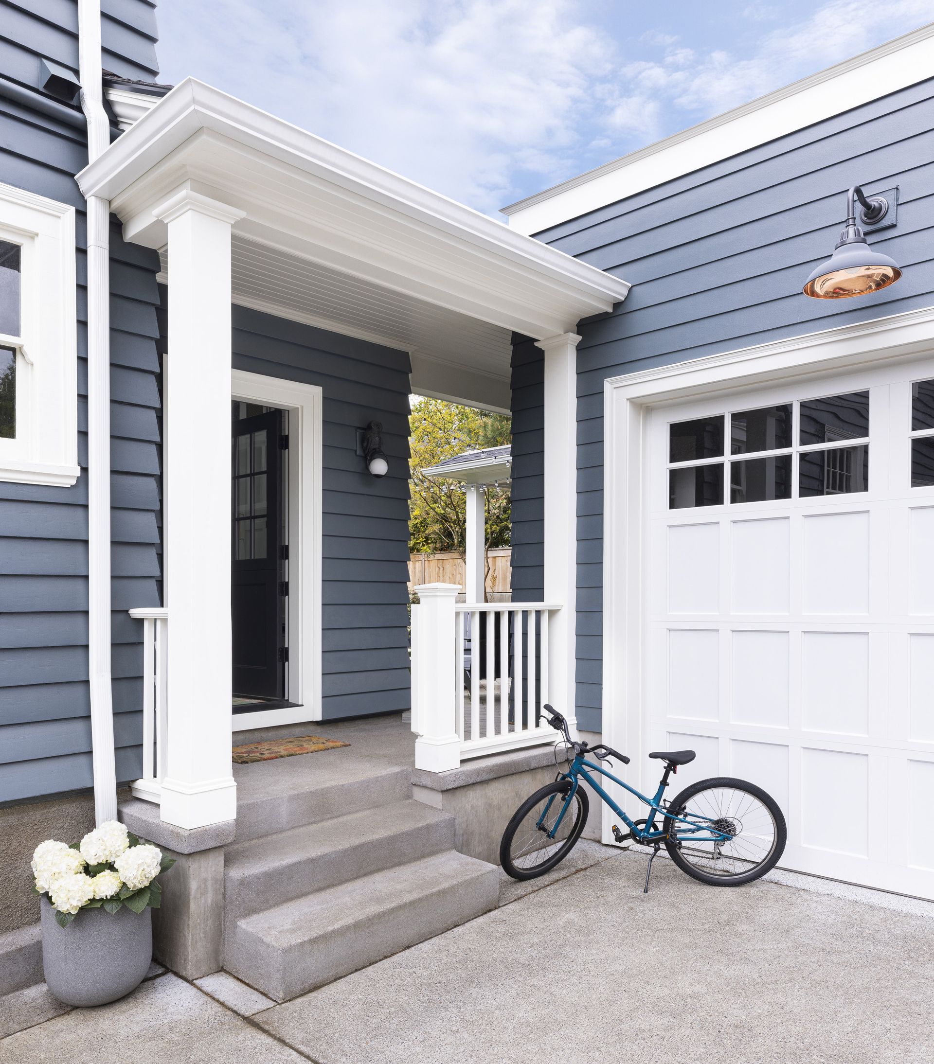 A new porch designed in conjunction with the mudroom addition connects with the new garage in this  1914 Laurelhurst Dutch Colonial. 