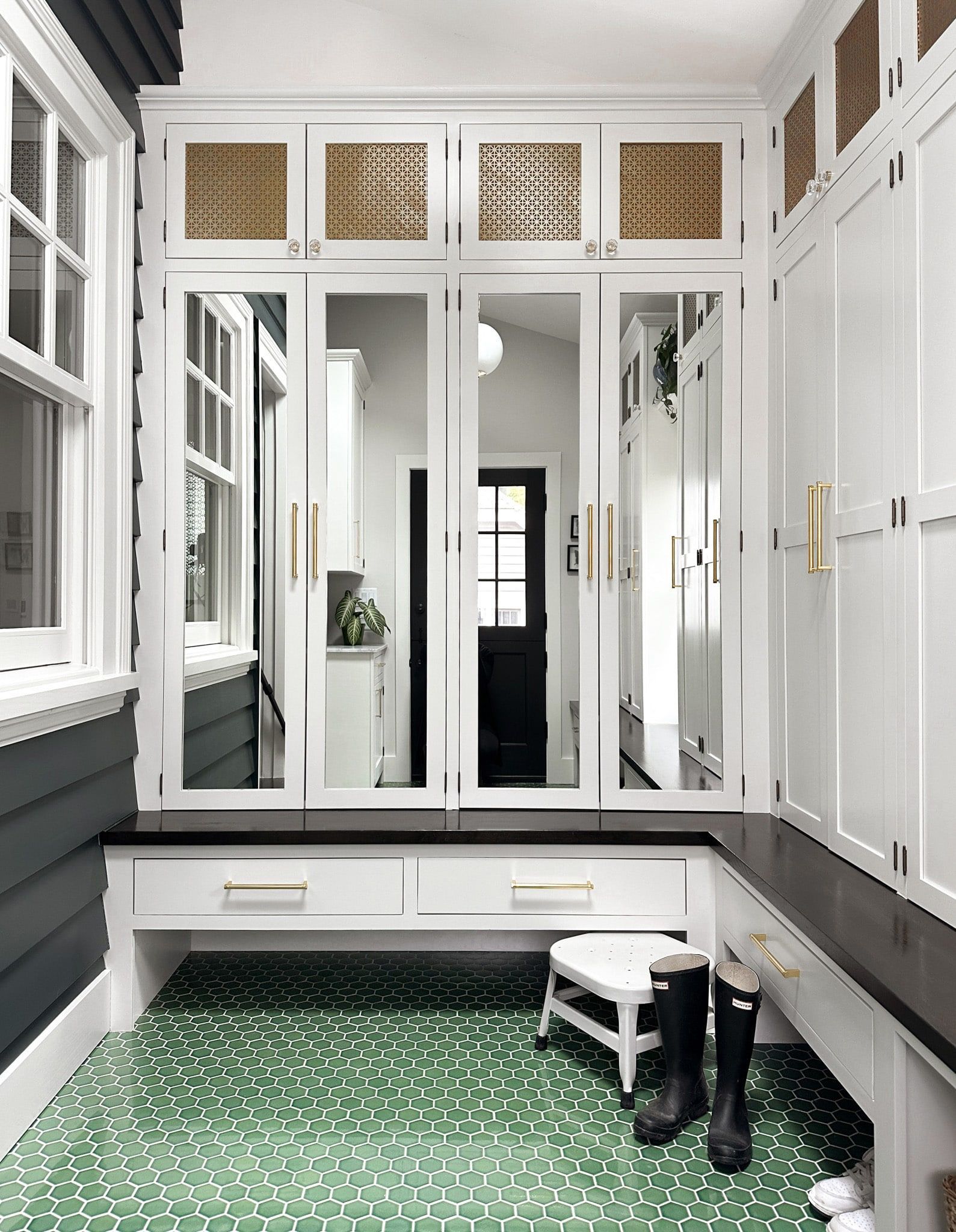 Opposite the dutch door is another wall of full height cabinets above the bench. These have mirrored doors, reflecting the light through the space and offering a place for last-minute fit check before heading out the door. 
