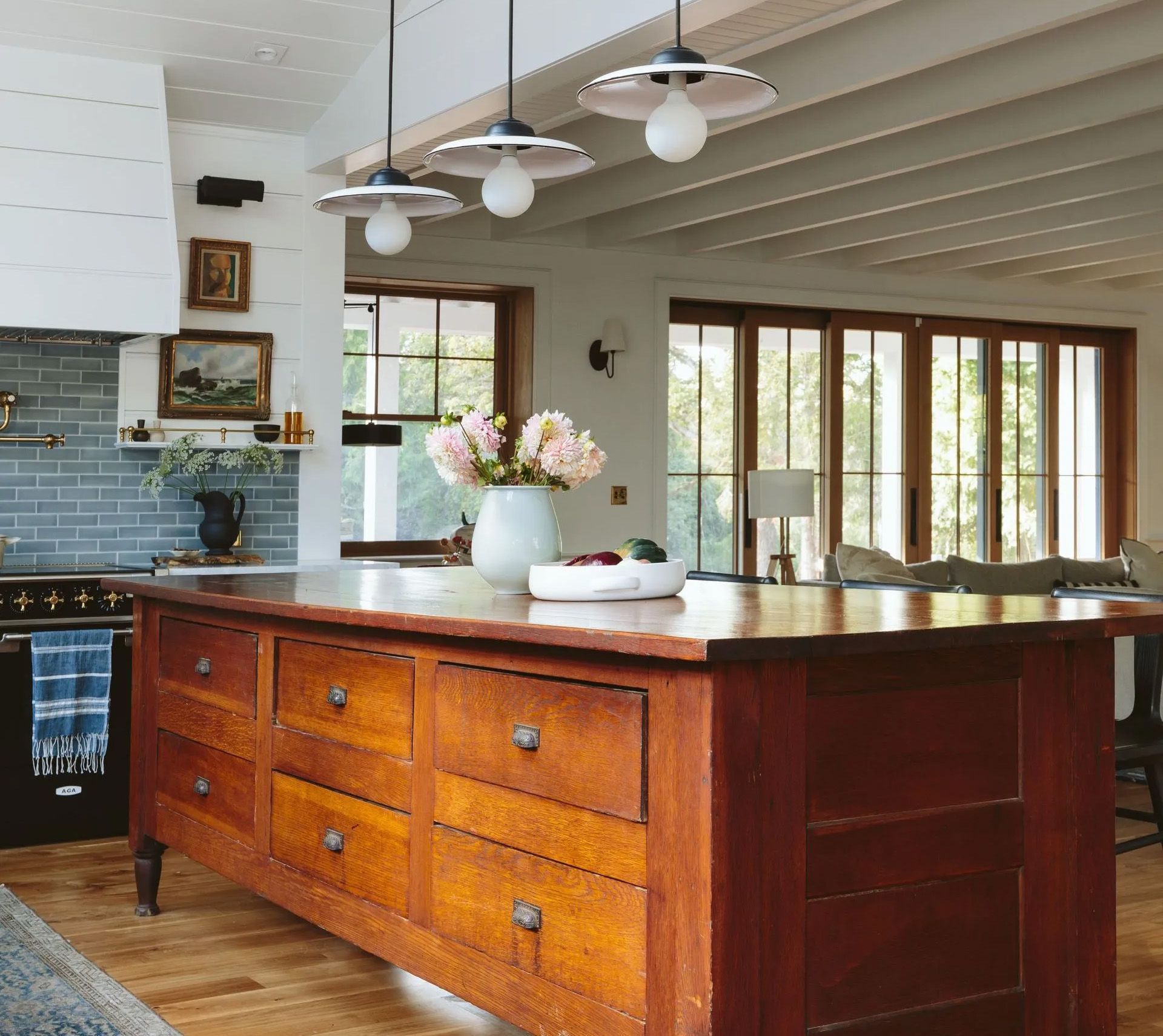 In this modernized 1910 farmhouse a huge antique work table divides the recently connected living room and kitchen. 