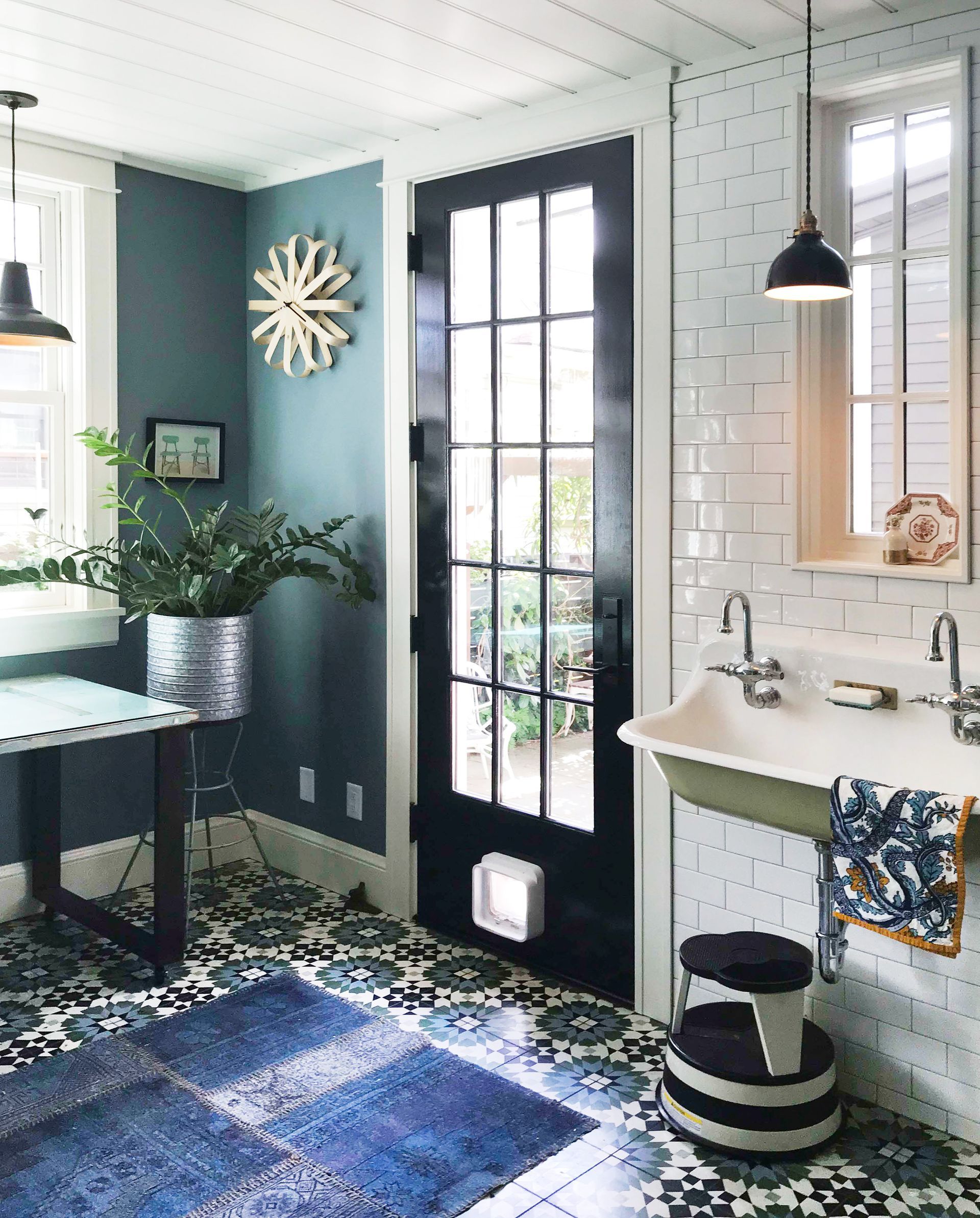 Opposite the wall of open shelving in the mudroom shown above, a utility sink by the door adds a practical place for washing up, as well as a dash of vintage style.