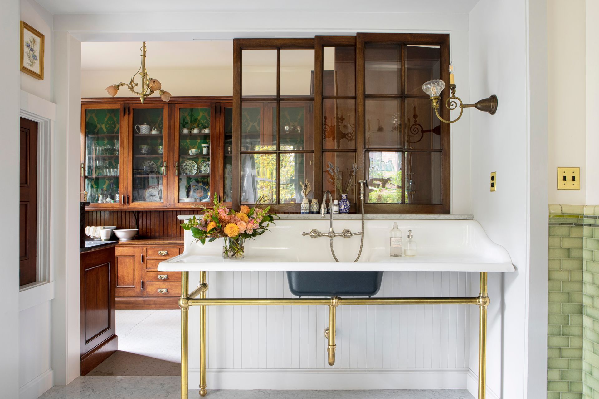 Salvaged sink on a custom brass console base with interior window above and original China Room beyond.