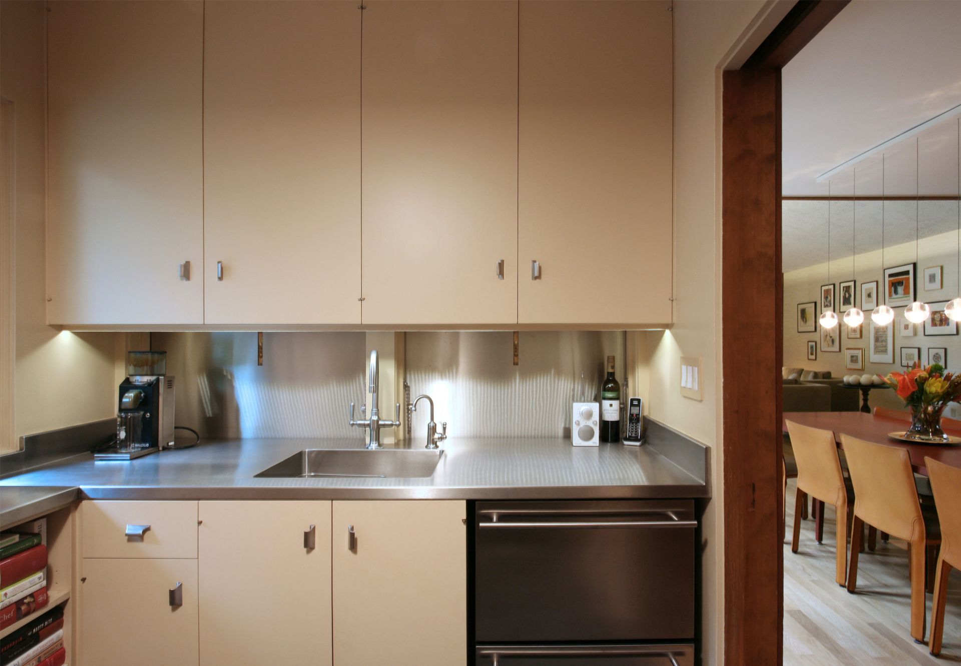 In this mid-century home, a rare butler's pantry provides space for clean-up, with extra dishwasher drawers and stainless counters.  The panels behind the sink open flat to create a handy serving surface.